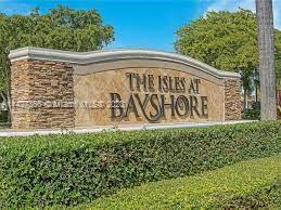 Entrance sign of 'The Isles at Bayshore' surrounded by greenery.