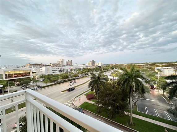 View from a balcony showing a cityscape with roads and buildings.