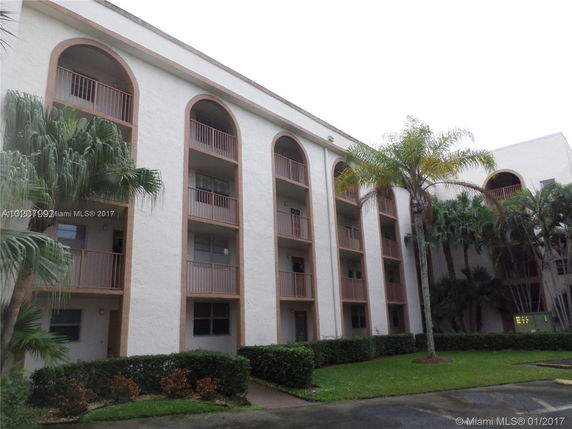 Front view of a multi-story apartment building with arched balconies.