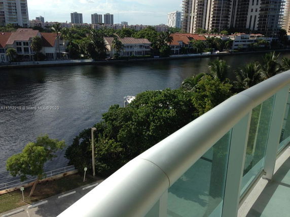 View from a balcony overlooking a river and nearby buildings.