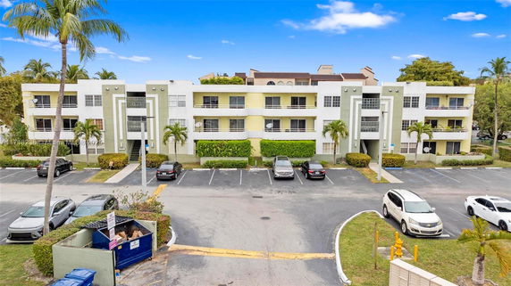 Front view of a three-story apartment building with parking area.