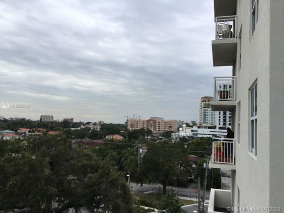 View from a building showing nearby residential and commercial buildings in the distance.