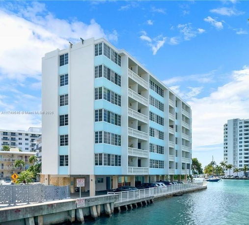 Front view of a multi-story apartment building by the water.