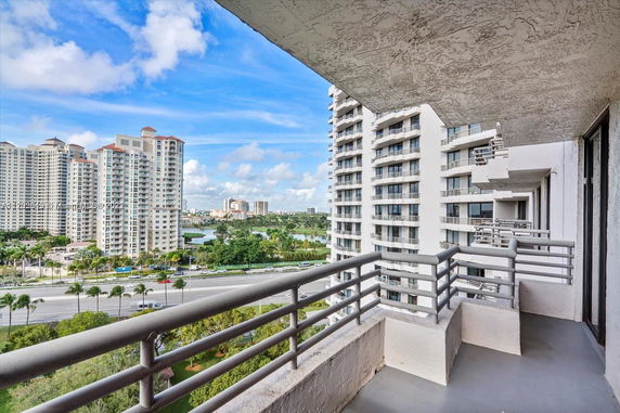 Panoramic view from a balcony showing high-rise buildings and a roadway.