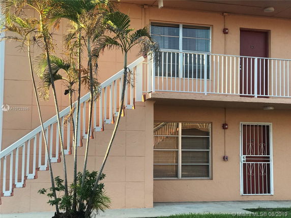 Front view of a two-story building with an outdoor staircase.
