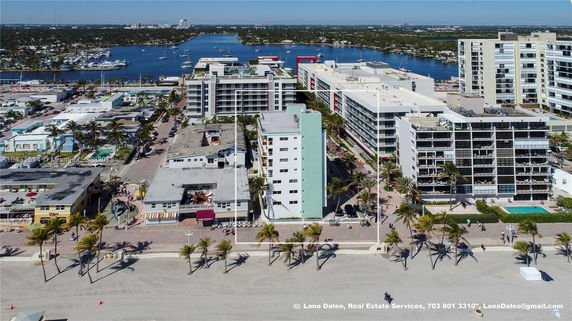 View of multiple buildings near a waterfront area, featuring a mix of low-rise and high-rise structures.