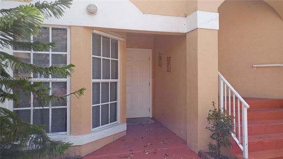 Front view of a house entrance with a door and windows.