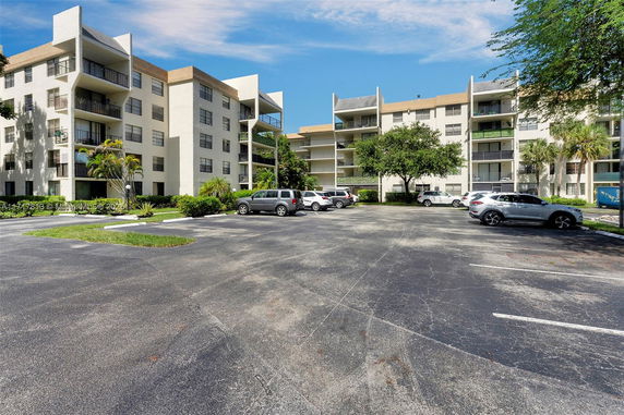 Outdoor parking area in front of a multi-story residential building.