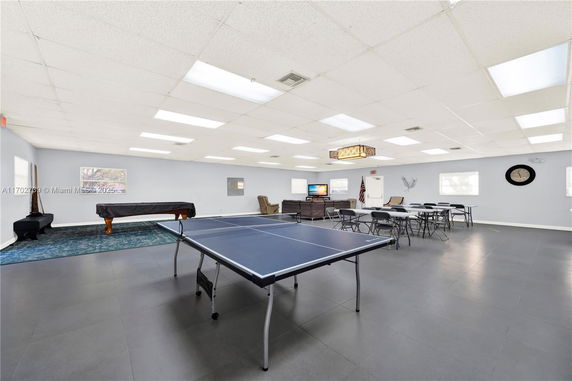 Indoor recreation room with a ping pong table and seating area.
