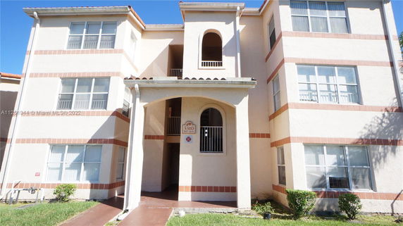 Front view of a three-story apartment building with arched entrance.