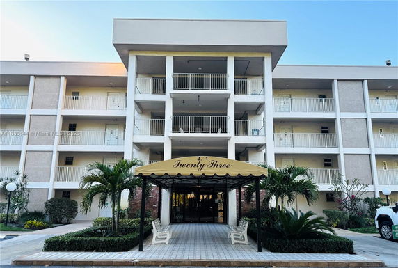Front view of a multi-story building with balconies and a covered entrance.