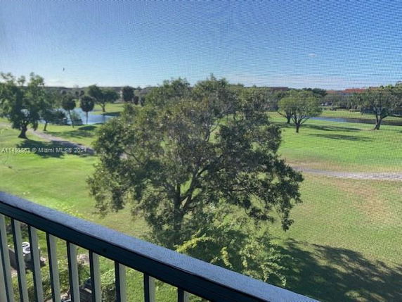 View from a balcony showing a landscape with trees and a waterbody.