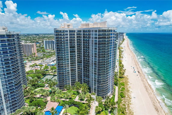 Aerial view of beachfront high-rise buildings with ocean and beach.