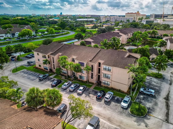Aerial view of a residential complex with multiple apartment buildings and parked cars.
