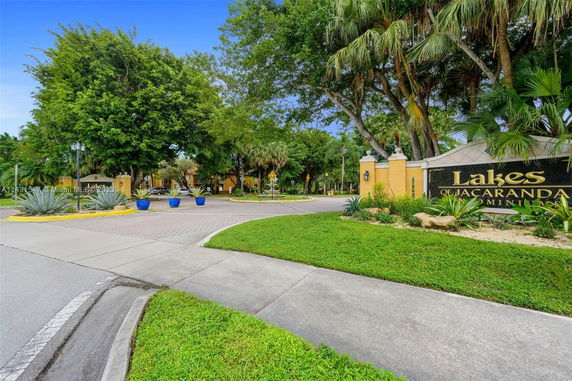 Entrance to Lakes of Jacaranda community with landscaped greenery and signage.