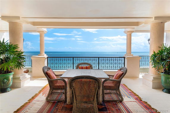 Outdoor patio with wicker furniture and ocean view.