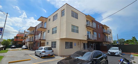 Front view of a multi-story apartment building with balconies.