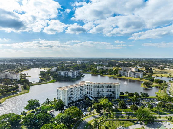 Aerial view of a residential complex surrounded by water and greenery.