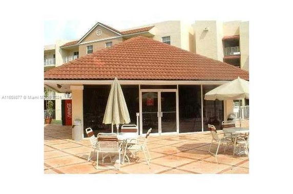 Front view of a building with a red tiled roof and a glass entrance.