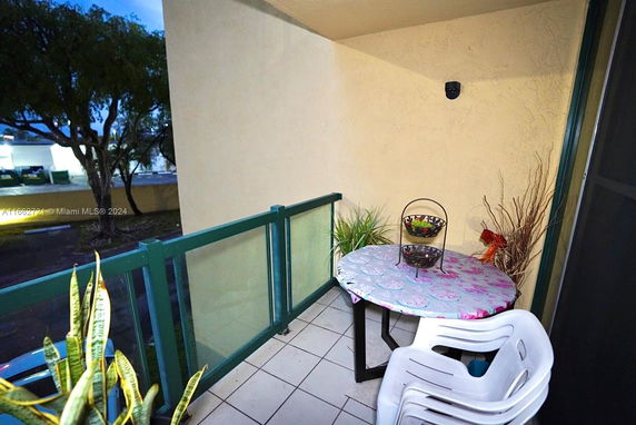 Balcony with a table and chairs overlooking surrounding area.