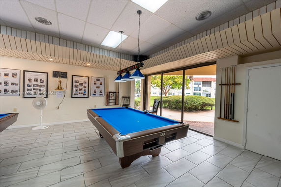 Indoor billiards room with pool table and wall decor.