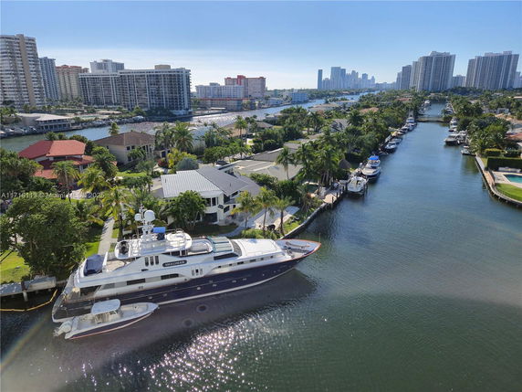 Aerial view of a waterfront residential area with buildings, boats, and canals.