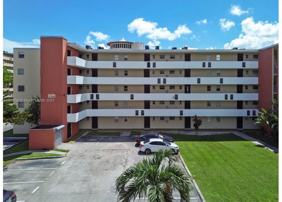 Front view of a multi-story apartment building with balconies.