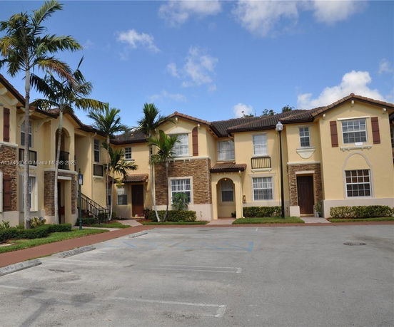 Front view of a two-story residential building with a mix of stone and stucco exterior.