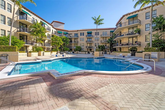 Outdoor swimming pool area surrounded by multi-story apartment buildings.