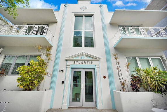 Front view of a multi-story building with balconies and decorative columns.