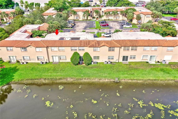 Rear view of a row of townhouses with waterway and parking area.