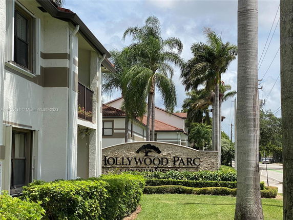 Front view of a multi-story building with a sign reading 'Hollywood Parc Condos'.