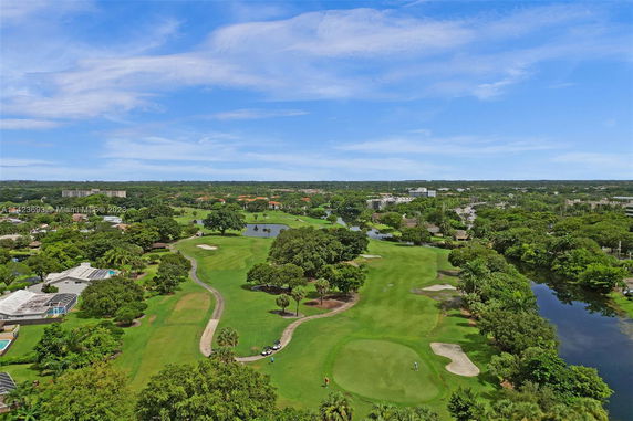 Panoramic view of a golf course and surrounding greenery.