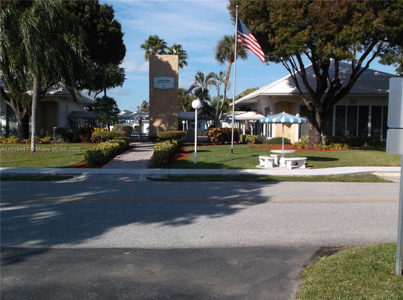 Front view of a building with a prominent rectangular stone column and an American flag.