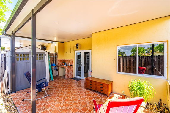 Outdoor patio area with seating and small utility shed.