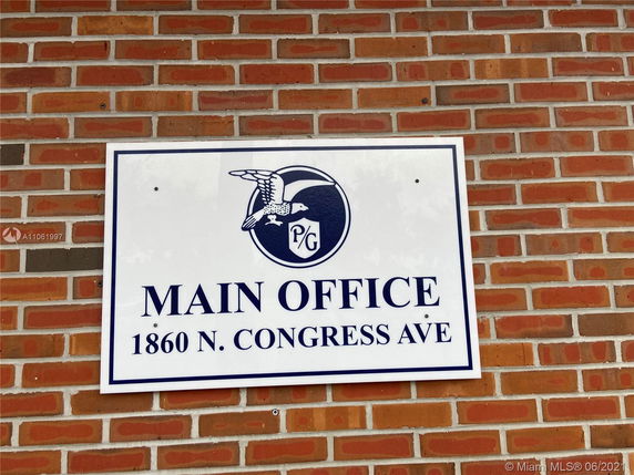 Brick wall with a sign reading 'Main Office 1860 N. Congress Ave.'