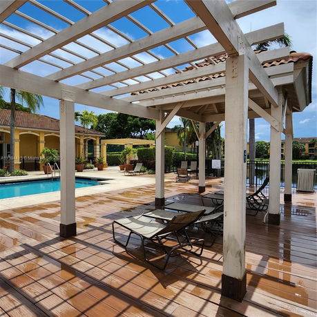 Outdoor area featuring a swimming pool with lounge chairs and a wooden pergola.