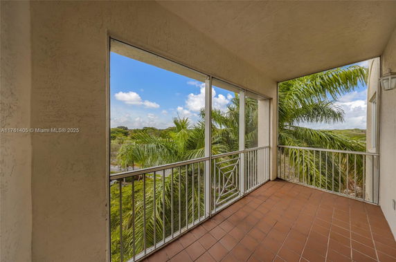 Covered terrace with a view of palm trees and the distant landscape.