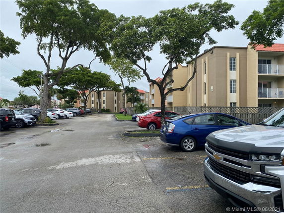 Outdoor parking area in front of a multi-story apartment building.