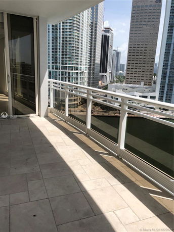 Balcony view of city skyscrapers with glass barriers.
