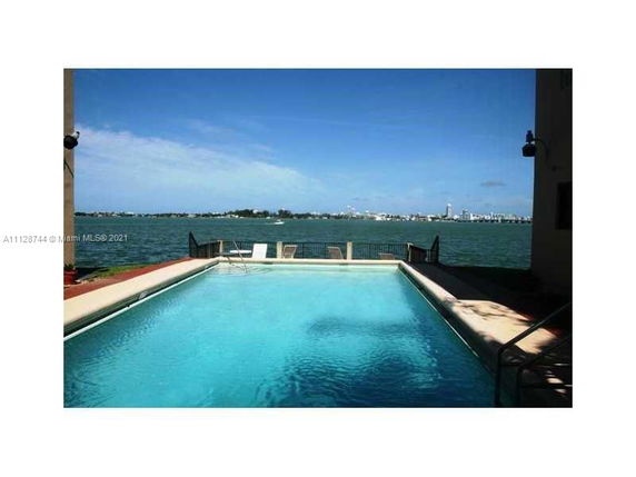 Outdoor swimming pool overlooking a body of water.
