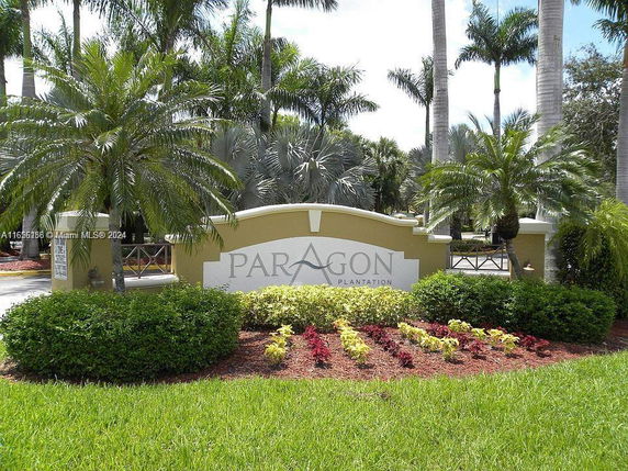 Entrance sign for Paragon Plantation surrounded by palm trees and landscaping.