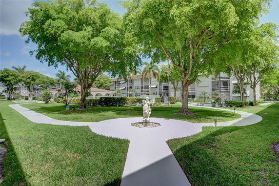 View of apartment buildings with pathways and greenery surrounding them.