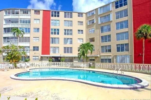 Swimming pool in front of a multi-story building.