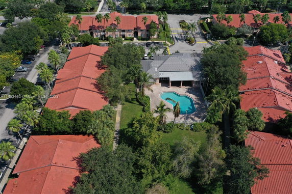 Aerial view of a community area with multiple buildings and a swimming pool.