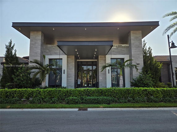 Front view of a modern single-story building with tall pillars and a flat roof.