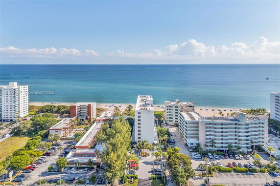 Panoramic view of beachside buildings with ocean backdrop.