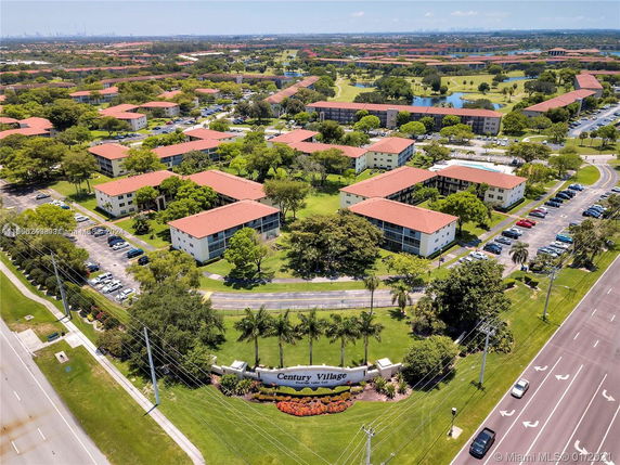 Aerial view of residential complex with multiple buildings and green spaces.