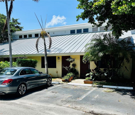 Front view of a building with a metal roof and multiple entrances.