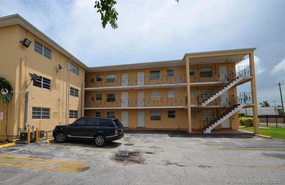 Front view of a three-story residential building with outdoor staircases.